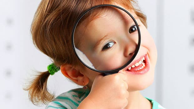 child holding magnifying glass