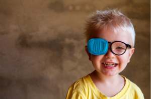 child in new glasses with patch for correcting squint treatment of strabismus lazy eye