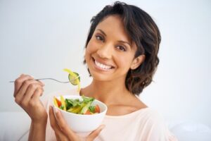Portrait of a young woman enjoying a salad at home