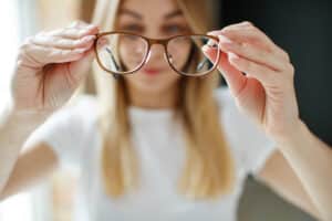 Woman holding up a pair of progressive glasses
