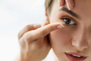 Woman applying contact lenses